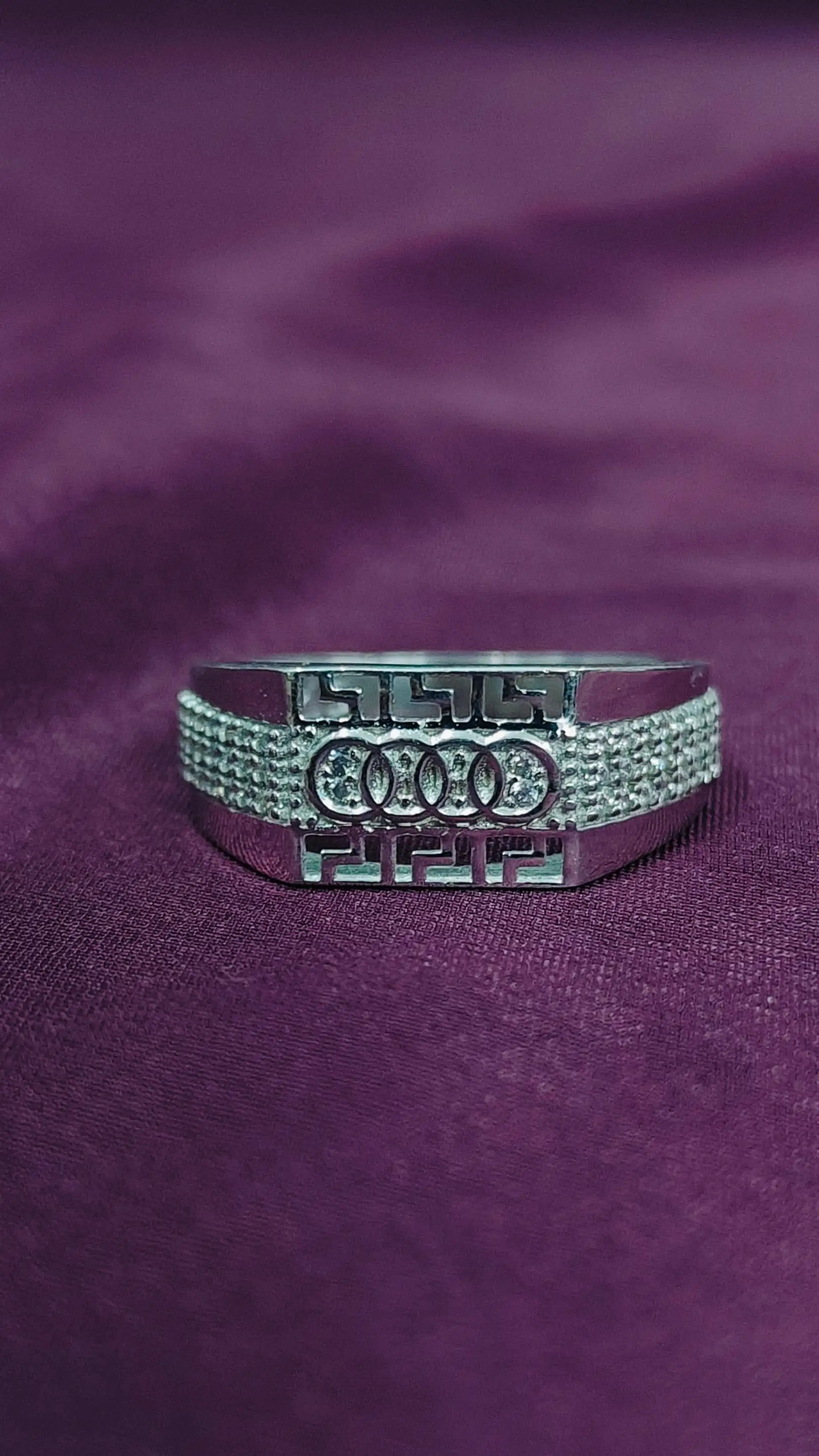 Silver Audi ring on a purple fabric background
